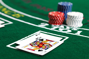 Grönt black jack bord med två kort och spelmarkörer på.